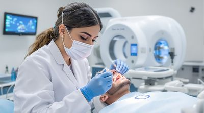 A dentist attaching a temporary bridge to implants during an All-on-4 surgery in an advanced Mexican dental facility.