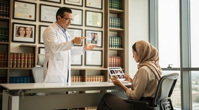 A surgeon reviews credentials and testimonials with an international patient during consultation.