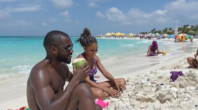 Multiracial American family enjoying Cancun beach between dental appointments under turquoise sky