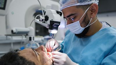Mexican endodontist performing molar root canal on American patient.