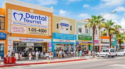 Bustling street scene of dental clinics in a Mexican tourism hub attracting diverse patients.